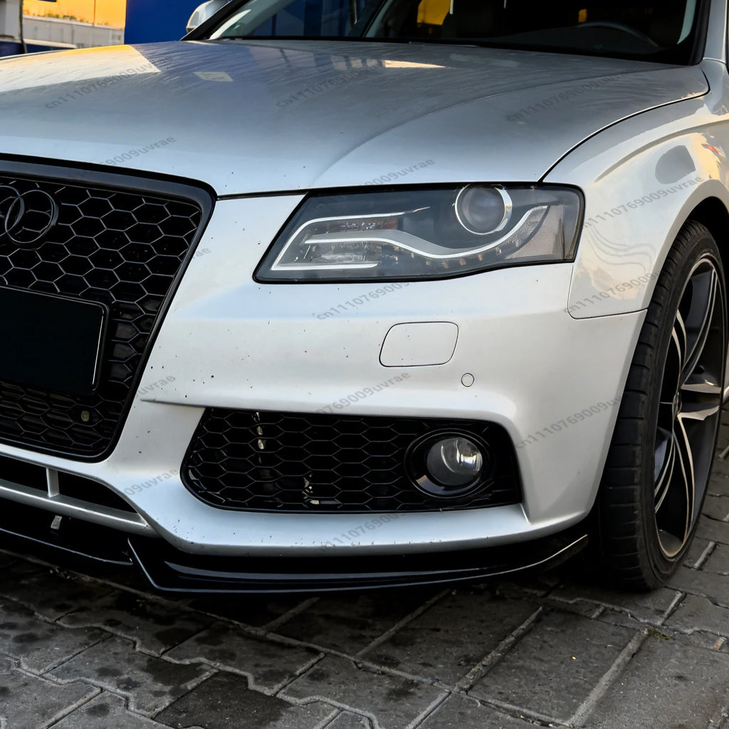 Close-up of the front bumper and grille area of a silver car, showing a black front lip installed on the silver body